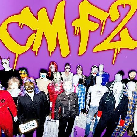 CMF 2 Albumcover in lila mit Puppen im Vordergrund und gelber Schrift